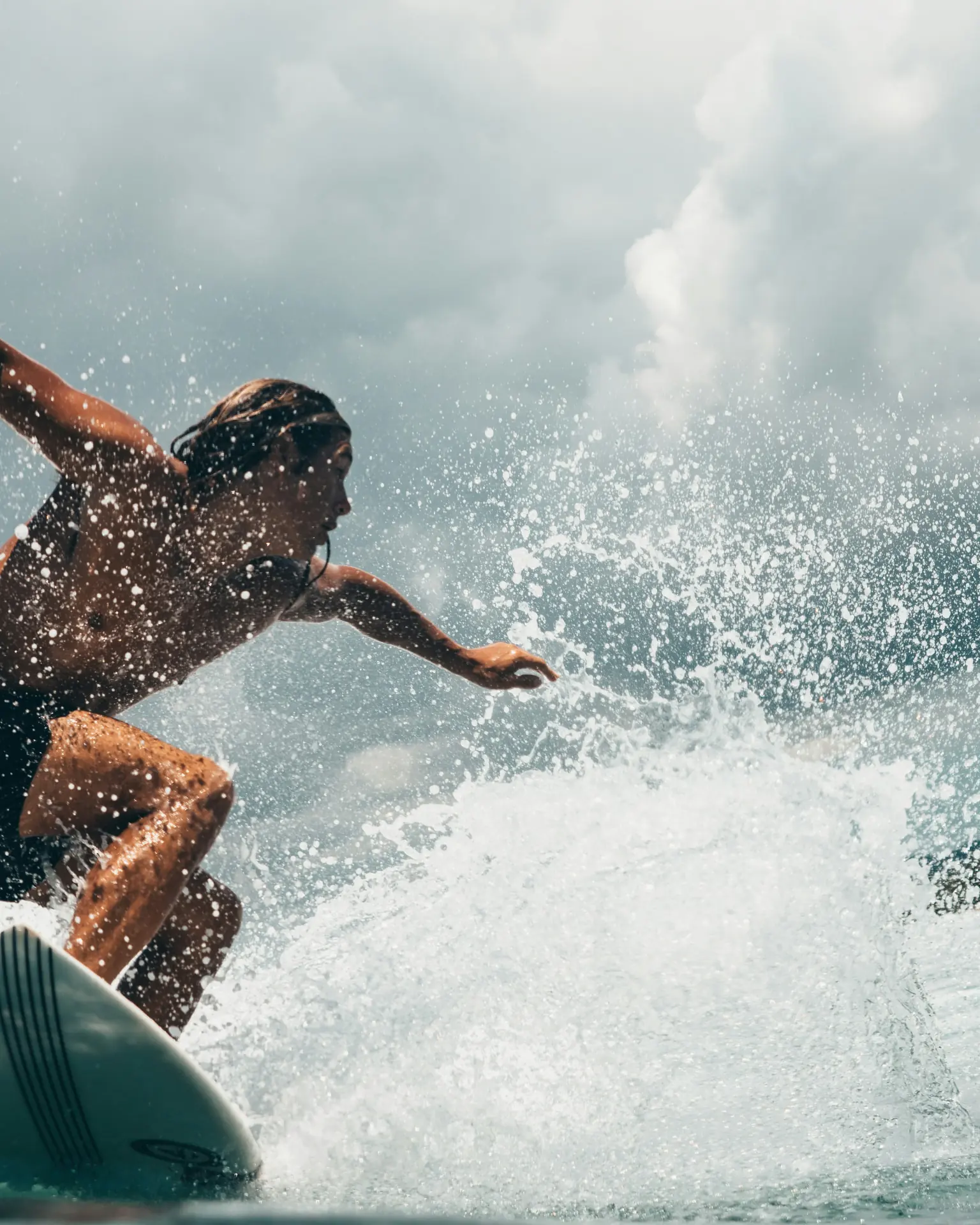 Surfös vág egy hullámot, permet a levegőben