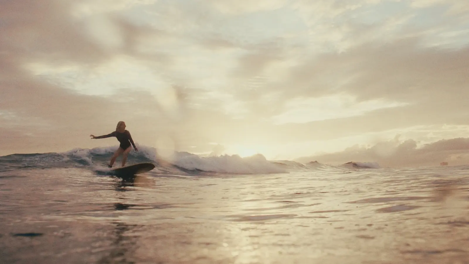 Longboardos surfös lány naplementében